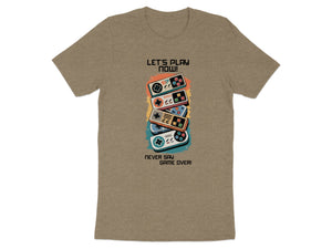 T-shirt with colorful retro video game controllers and text "LET'S PLAY NOW! NEVER SAY GAME OVER!"