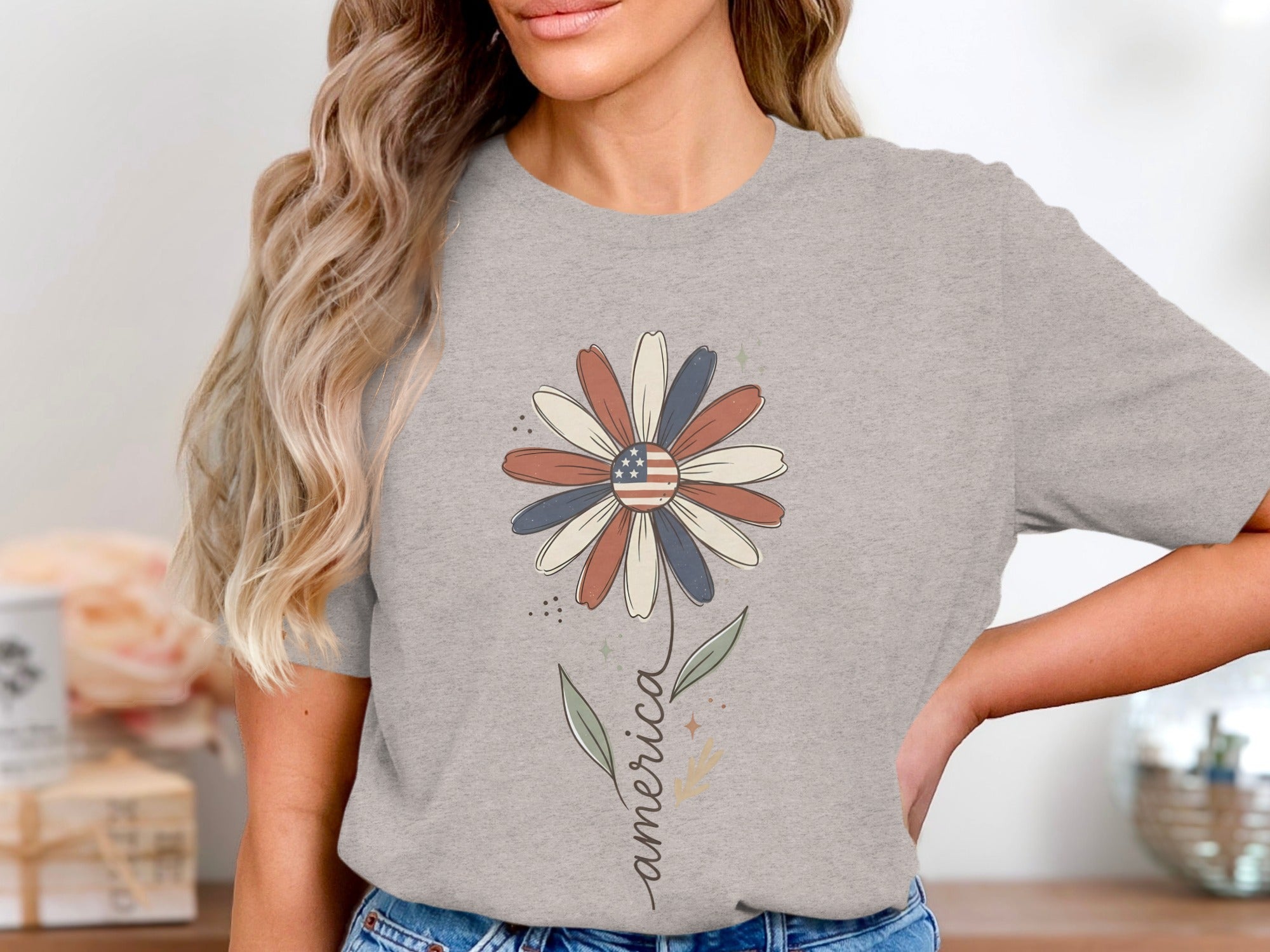 Grey t-shirt with a daisy graphic featuring an American flag center and the word "america".