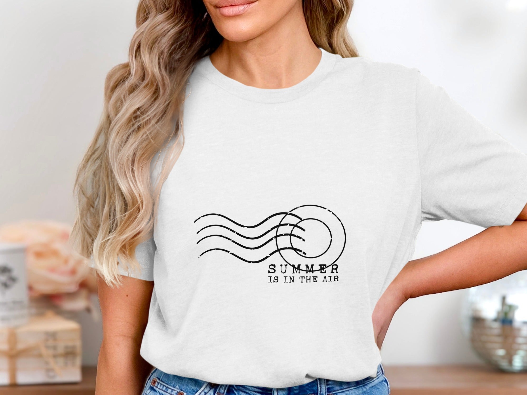 White t-shirt with "SUMMER IS IN THE AIR" text and wavy lines graphic.