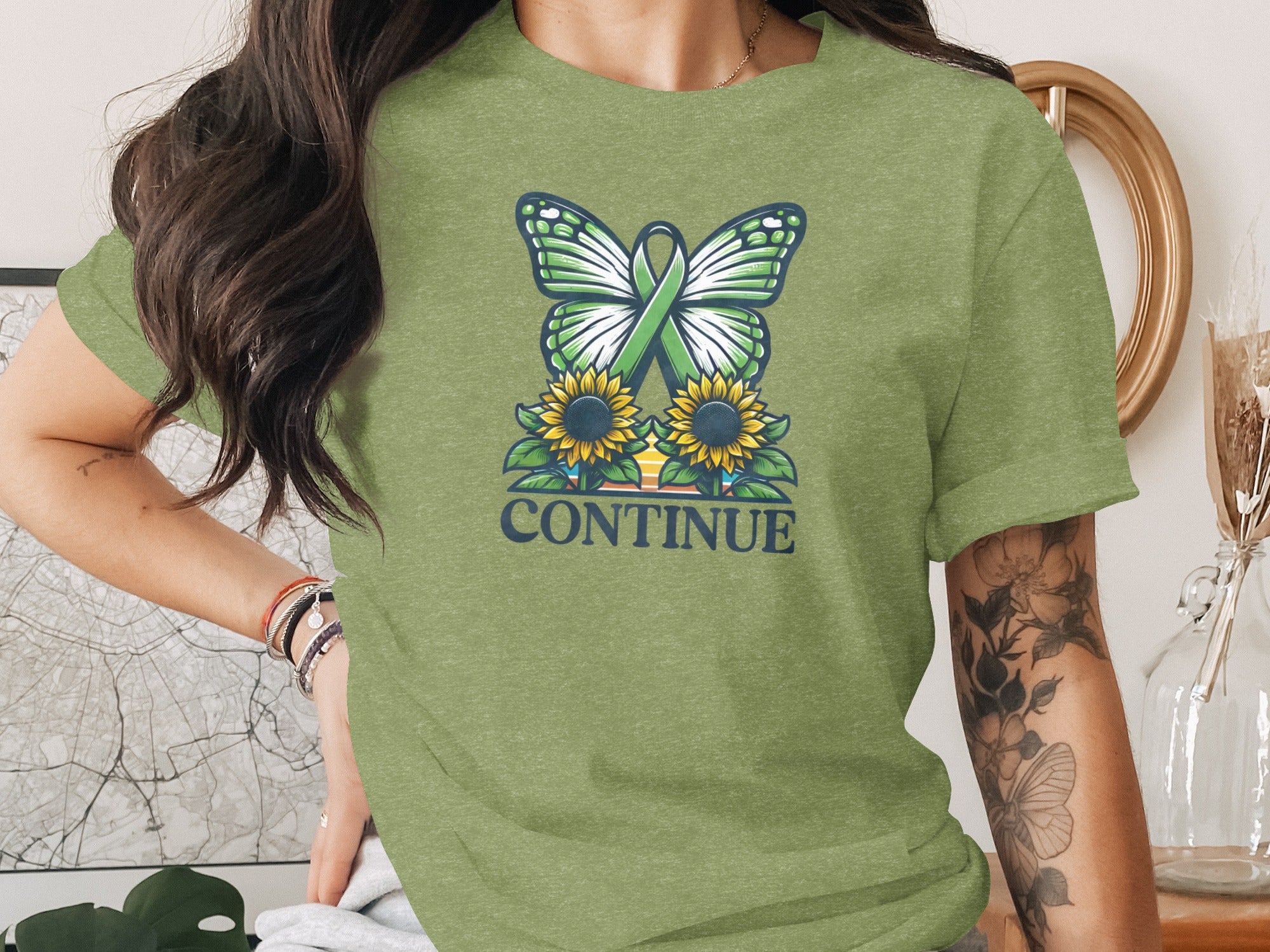 Green butterfly with awareness ribbon over sunflowers, text "CONTINUE".
