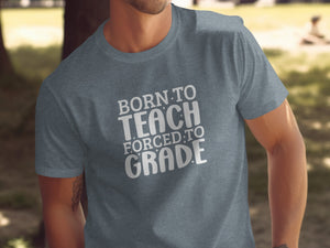Grey t-shirt with white text that reads "BORN TO TEACH FORCED TO GRADE".