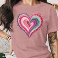 Pink t-shirt with a colorful, layered heart graphic with gold accents.