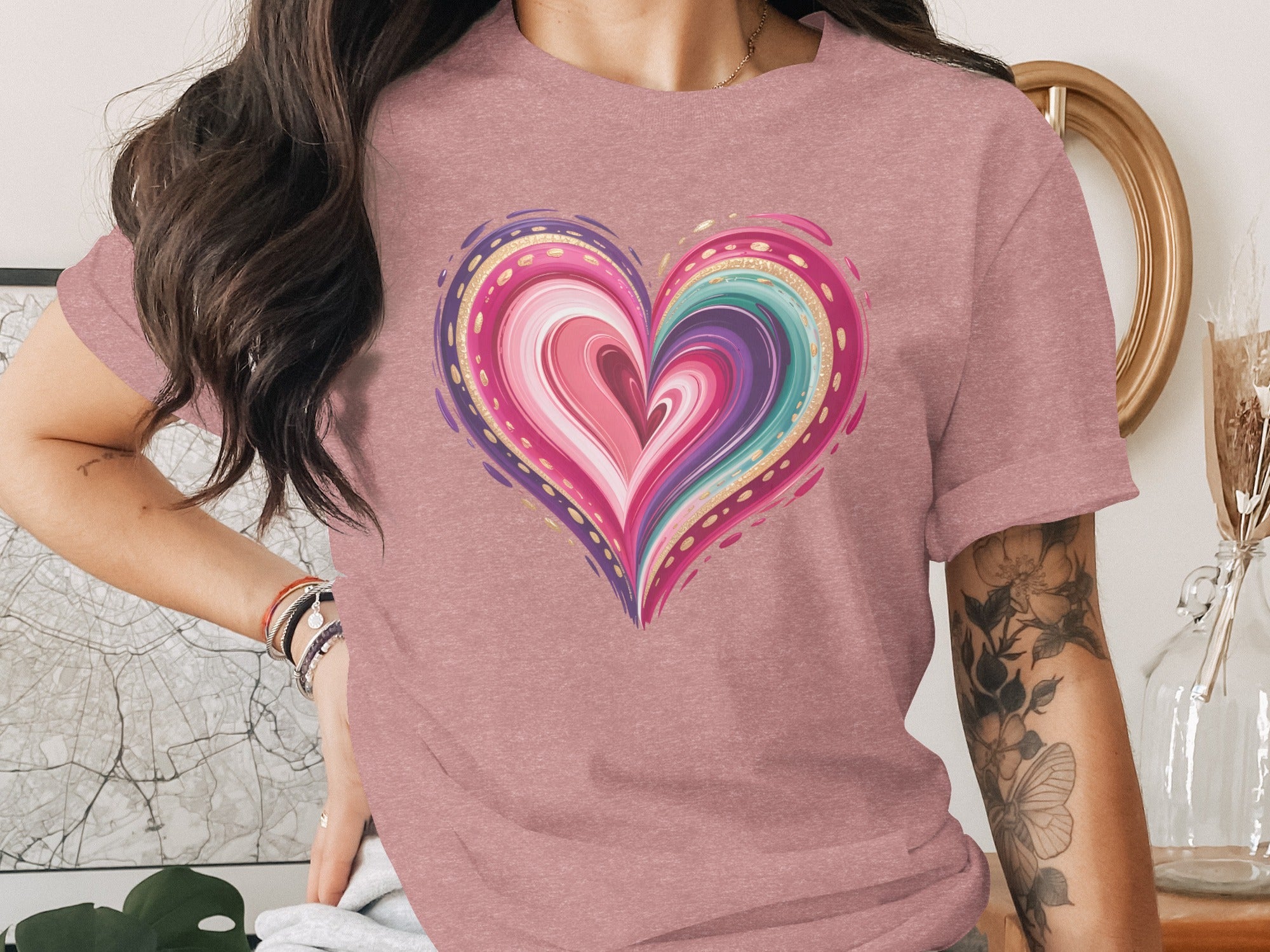 Pink t-shirt with a colorful, layered heart graphic with gold accents.