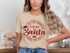 Light tan t-shirt with red text and Santa hat graphic.