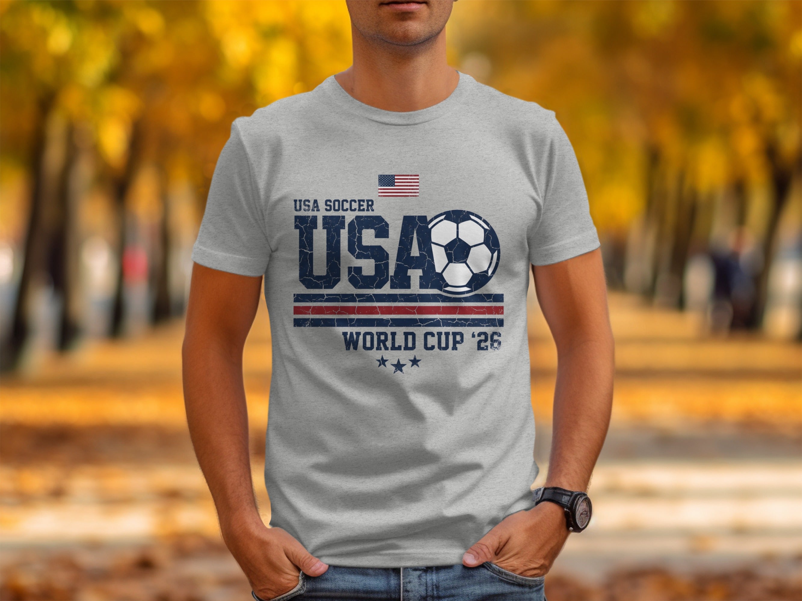 Grey t-shirt with USA Soccer World Cup '26 graphic and American flag.