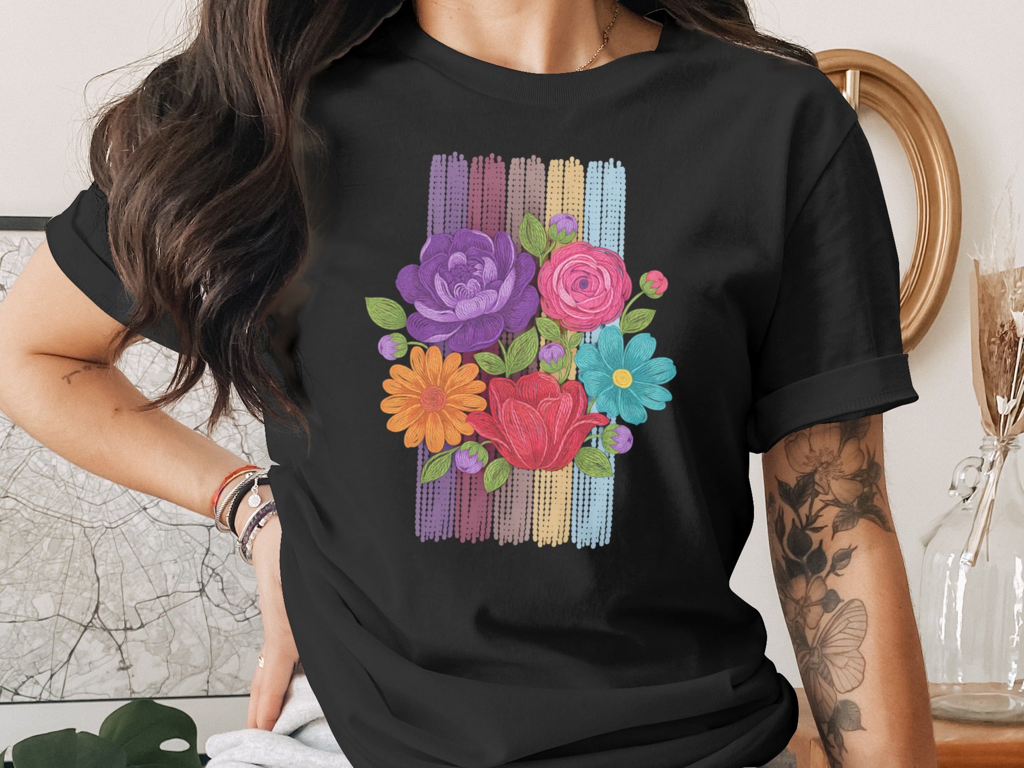 Black t-shirt with a colorful floral bouquet design on a striped background.