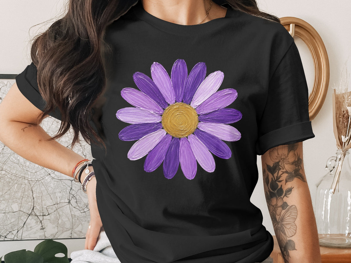 Black t-shirt with a painted purple daisy and gold center graphic.