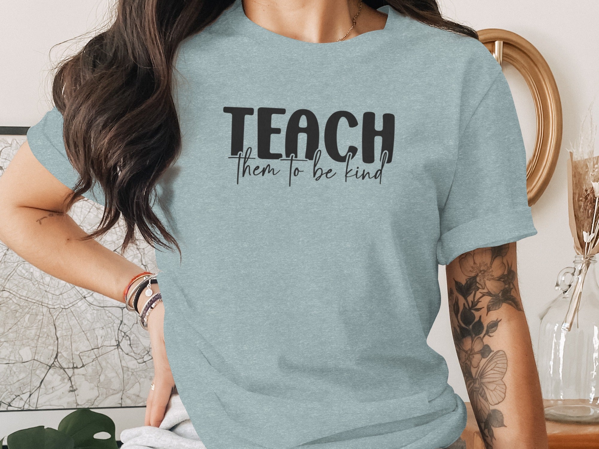 Light blue t-shirt with black text "TEACH them to be kind"