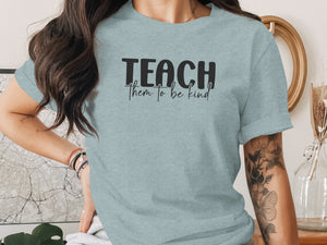 Light blue t-shirt with black text "TEACH them to be kind"