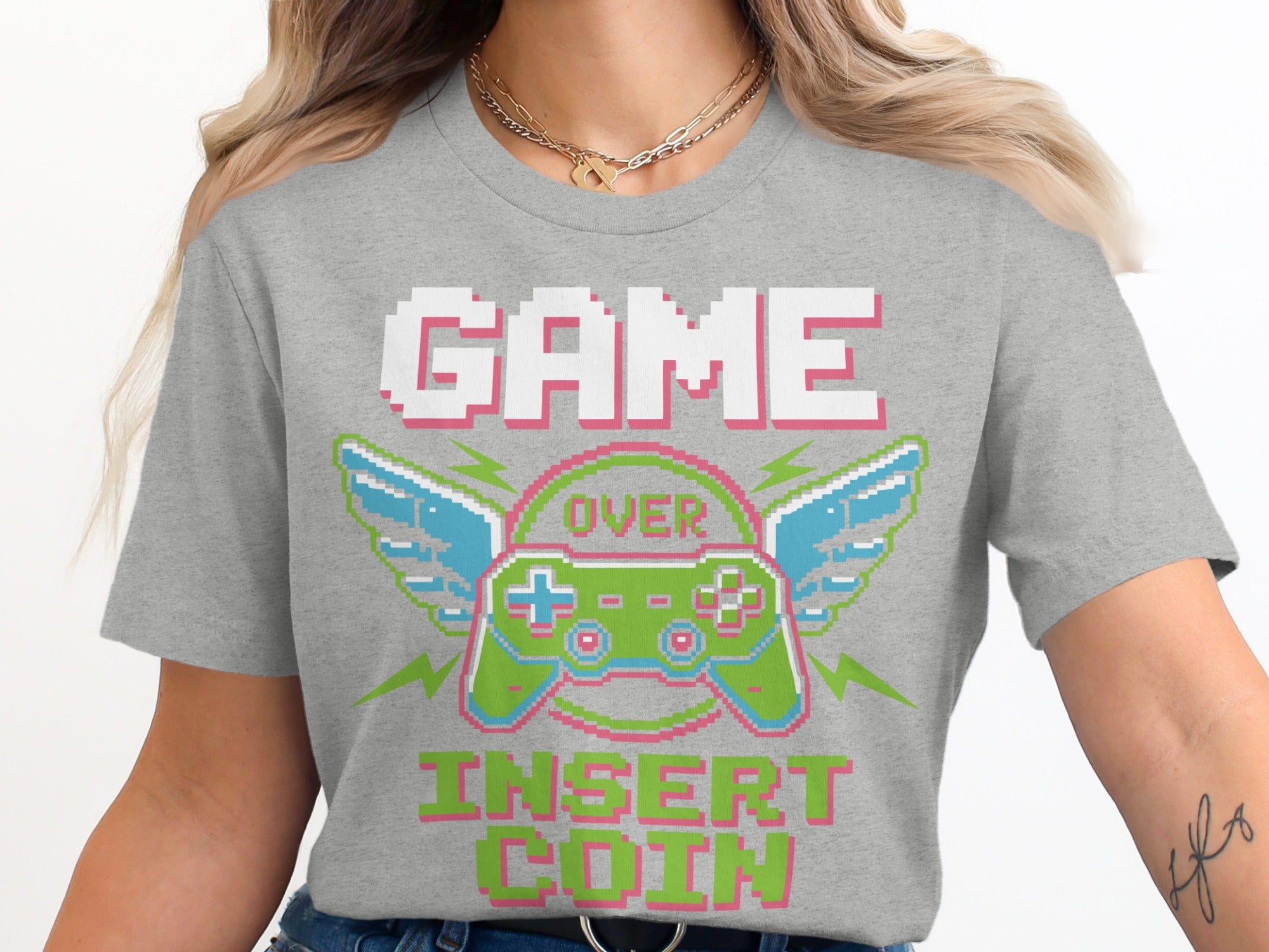Grey t-shirt with pixel art "GAME OVER INSERT COIN" and controller with wings.