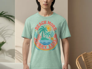 Green t-shirt with a circular graphic of palm trees, sun, ocean, and the words "Beach More Worry Less."