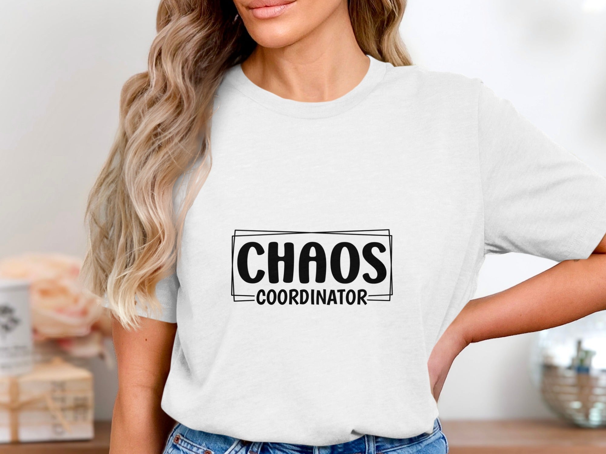 White t-shirt with "CHAOS COORDINATOR" text in a black rectangle and border.