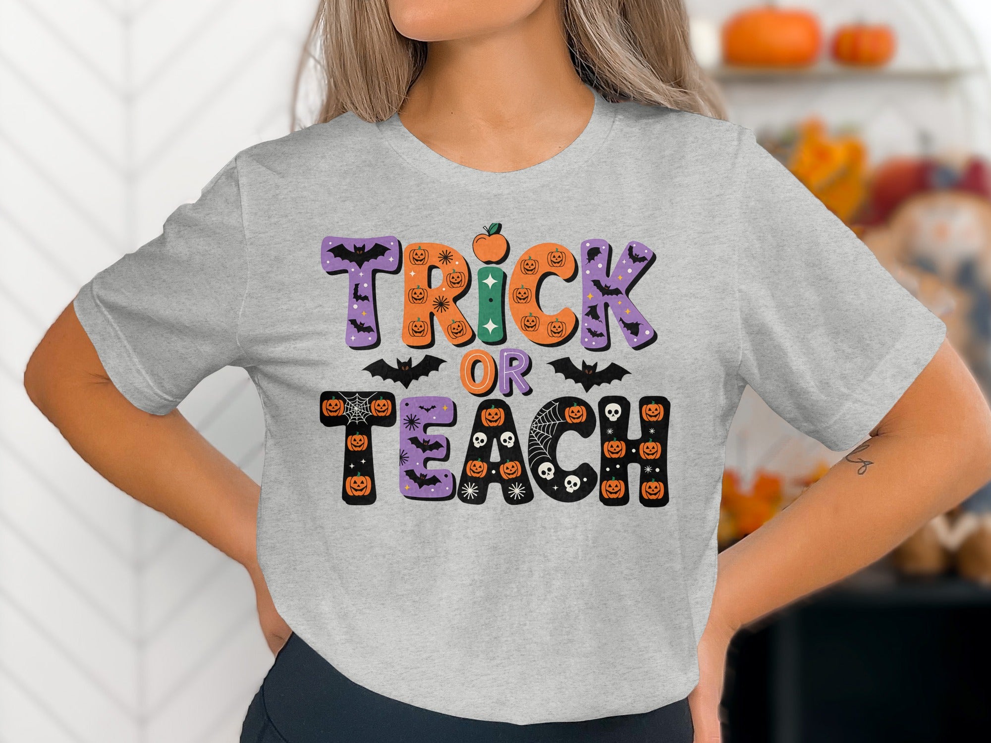 Grey t-shirt with "Trick or Teach" Halloween text and spooky graphics.