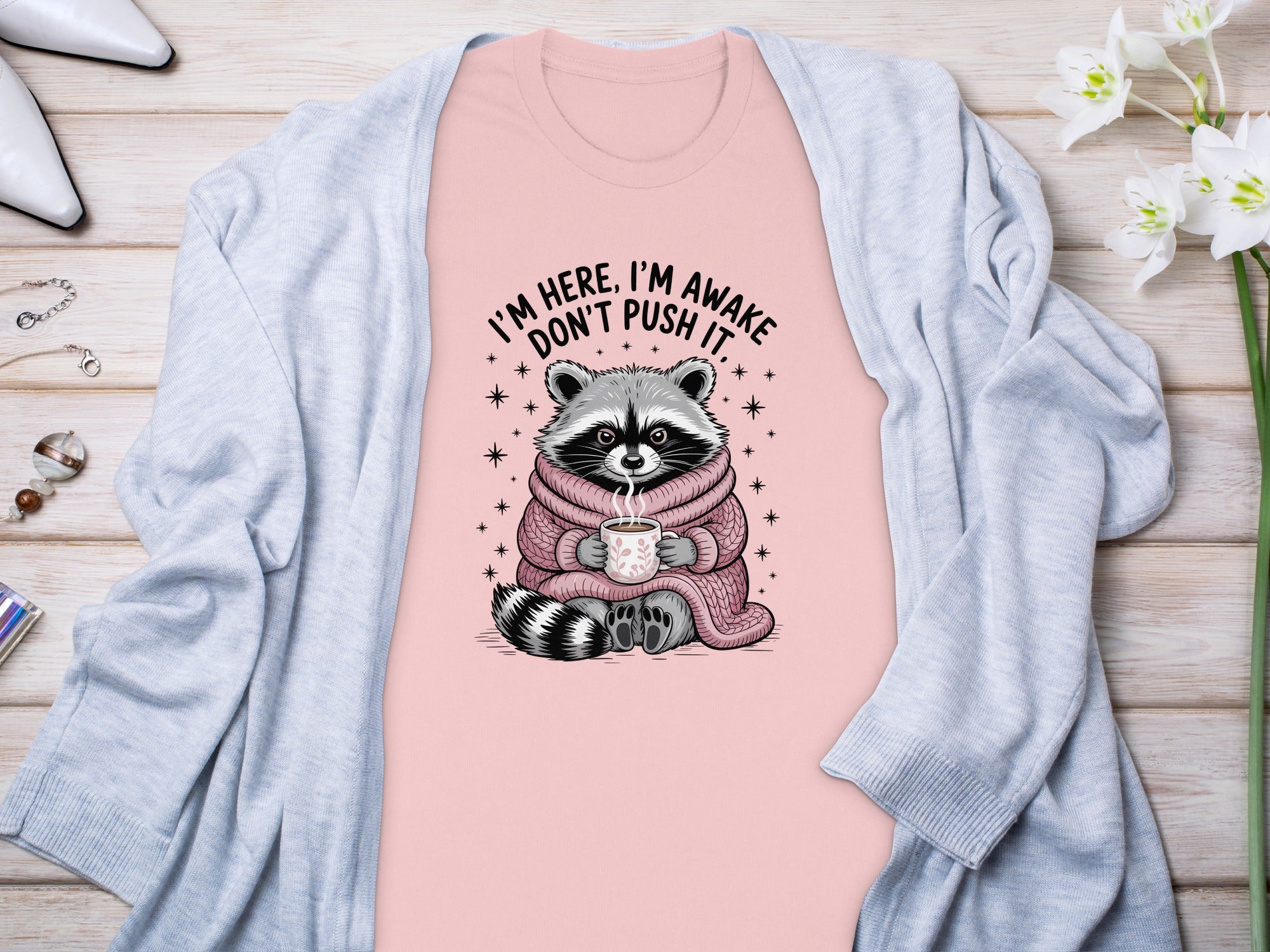 Pink t-shirt with raccoon graphic and text "I'M HERE, I'M AWAKE DON'T PUSH IT."