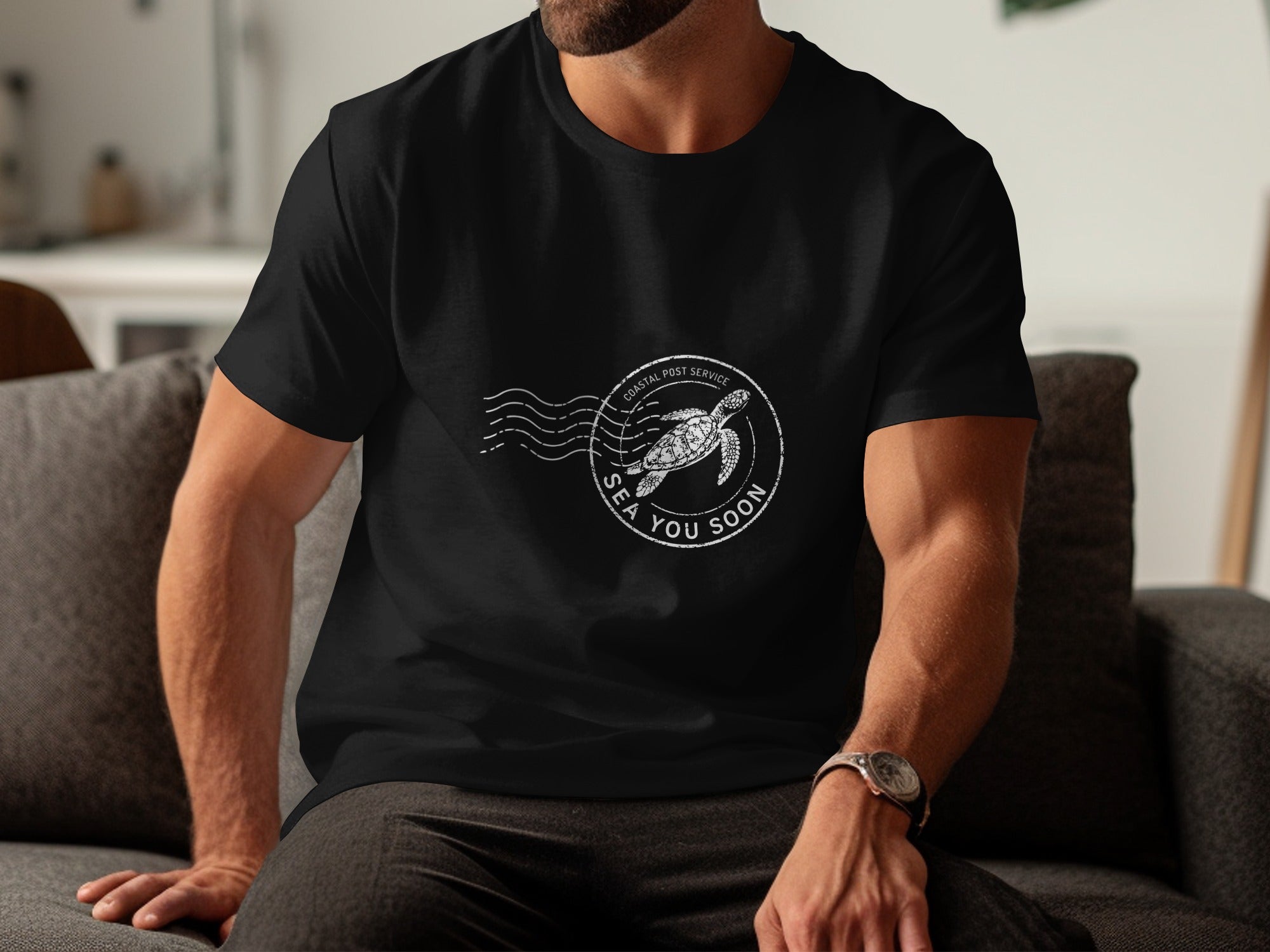 Black t-shirt with circular stamp graphic of sea turtle and text "Coastal Post Service Sea You Soon."