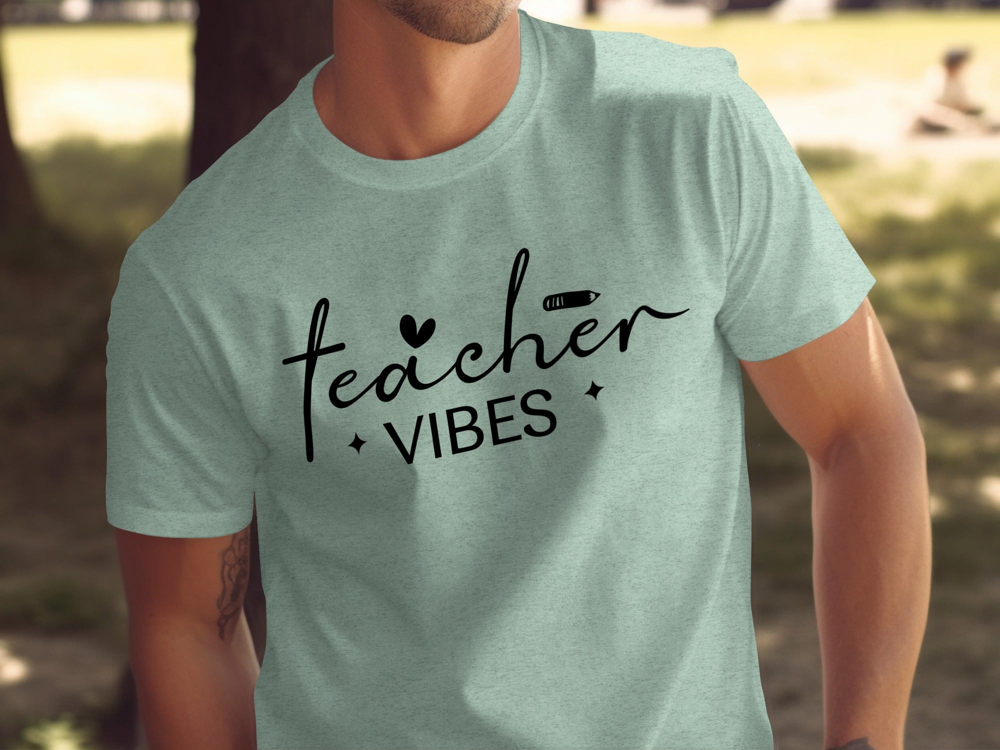 Green t-shirt with black text "teacher VIBES" and graphic elements.
