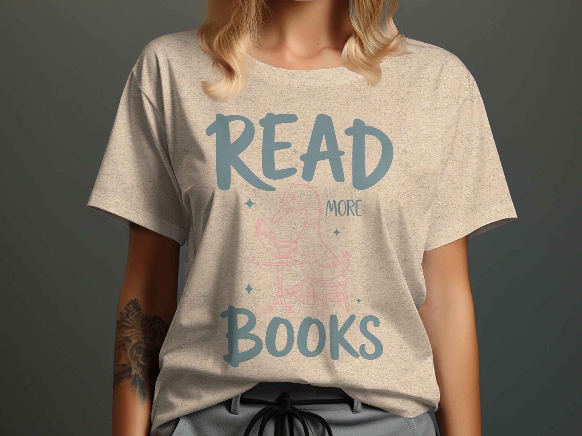 Light grey t-shirt with "READ MORE BOOKS" text and a pink duck reading a book.