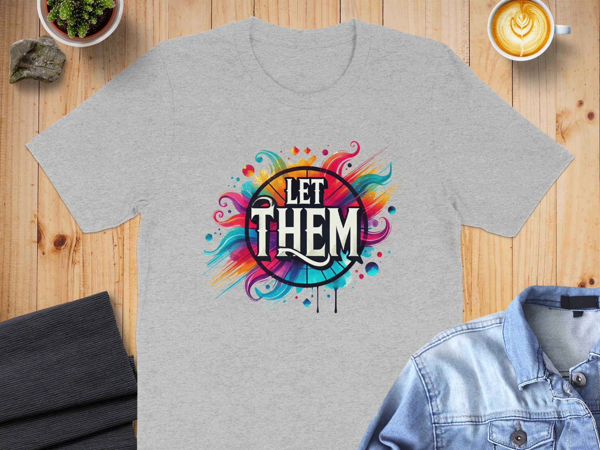 Grey t-shirt with "LET THEM" text and colorful swirling abstract design.