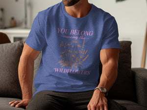 Blue t-shirt with pink text "YOU BELONG - among the - WILDFLOWERS" and botanical graphic.