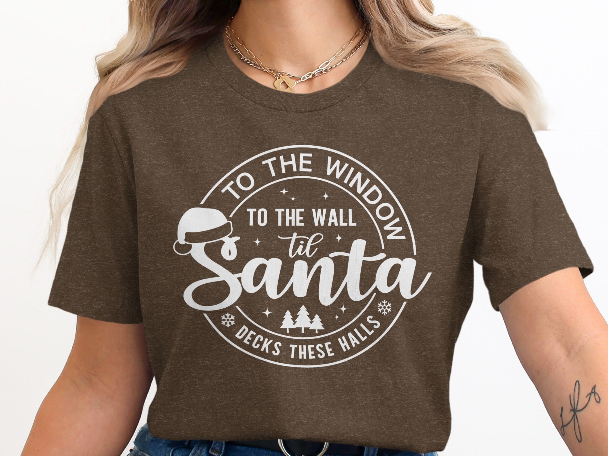 Brown t-shirt with white text: "To the window, to the wall 'til Santa decks these halls."