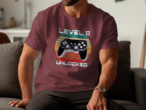 Maroon t-shirt with vintage game controller graphic and text LEVEL 11 UNLOCKED.
