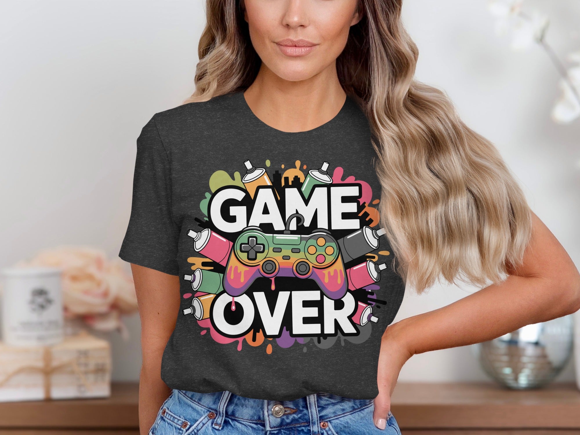 Dark t-shirt with "GAME OVER" text, colorful paint cans, and a video game controller.