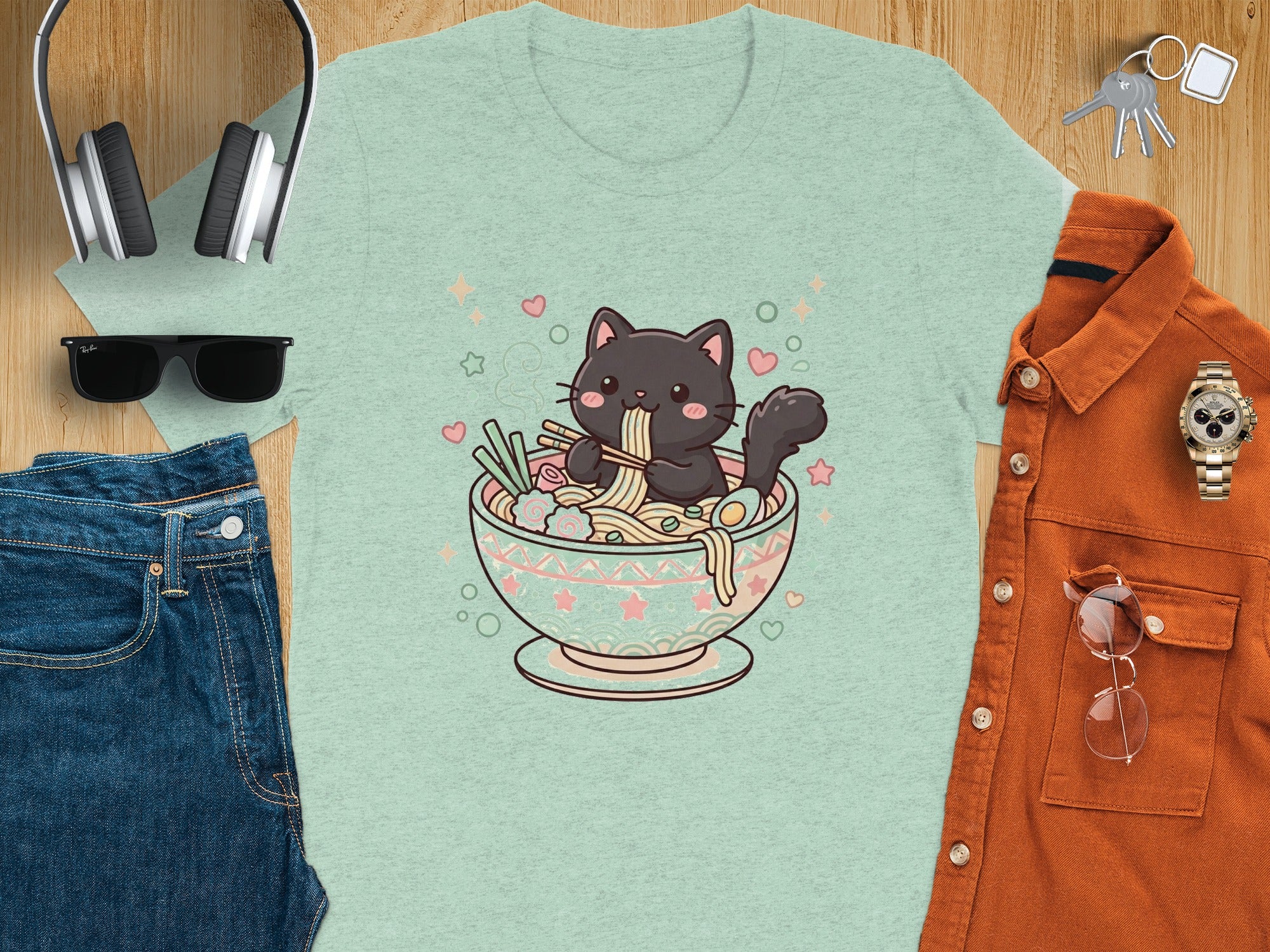 Cute black cat eating ramen in a bowl on a light green t-shirt.
