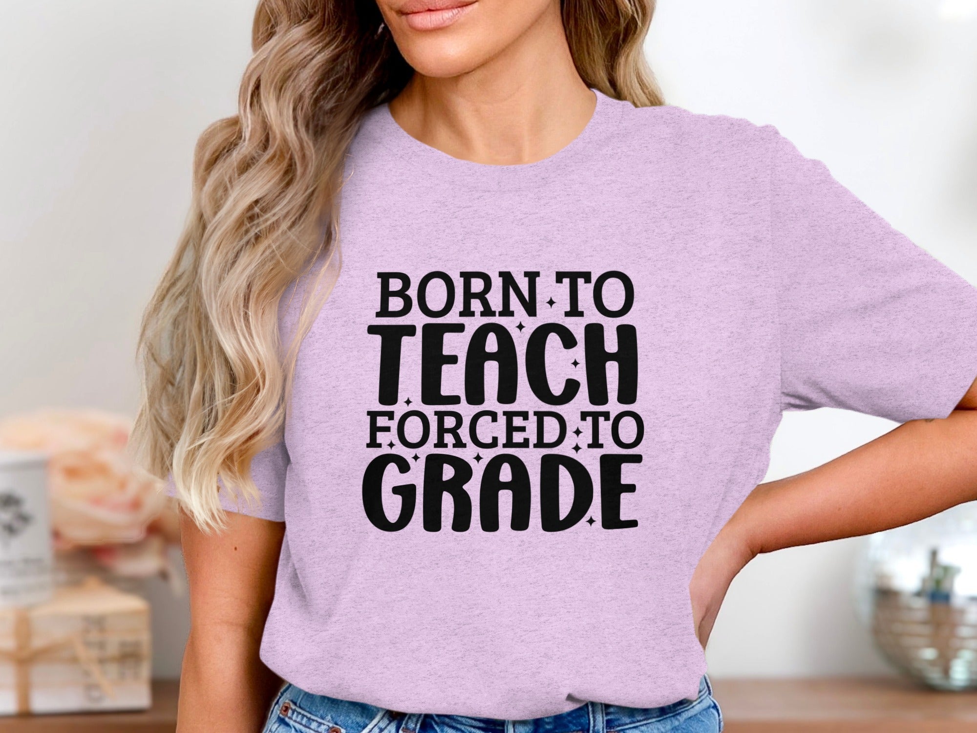 Light purple t-shirt with black text "BORN TO TEACH FORCED TO GRADE"