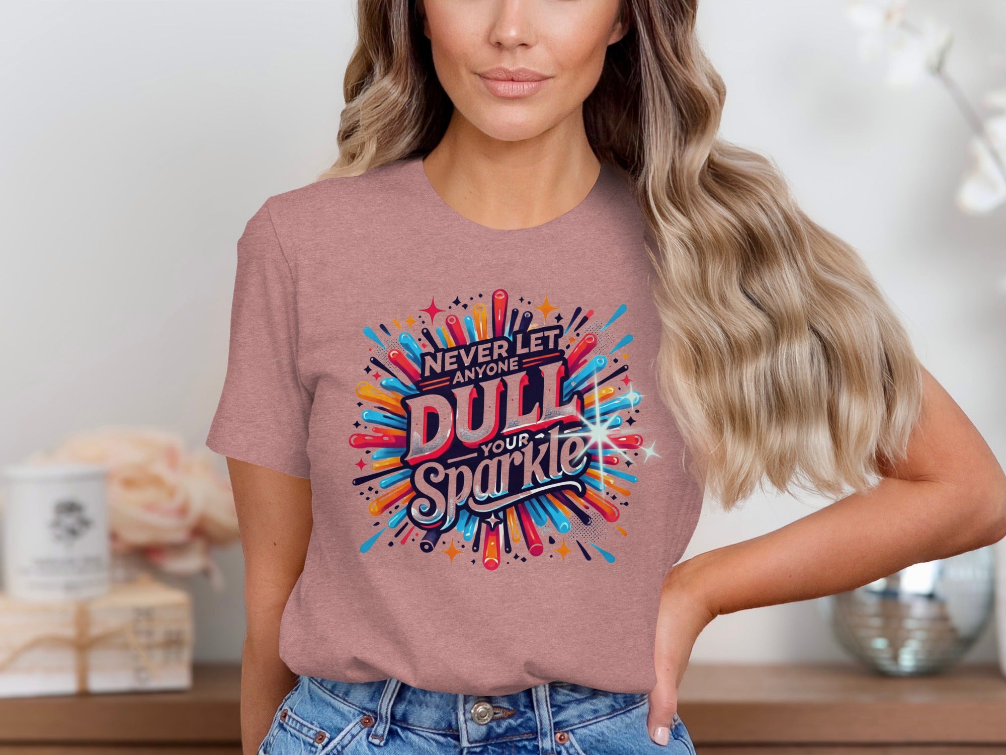 T-shirt with colorful "Never Let Anyone Dull Your Sparkle" graphic and playful explosions.