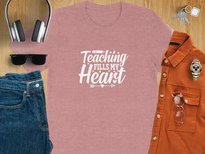 Pink t-shirt with white text "Teaching Fills My Heart" among other items.