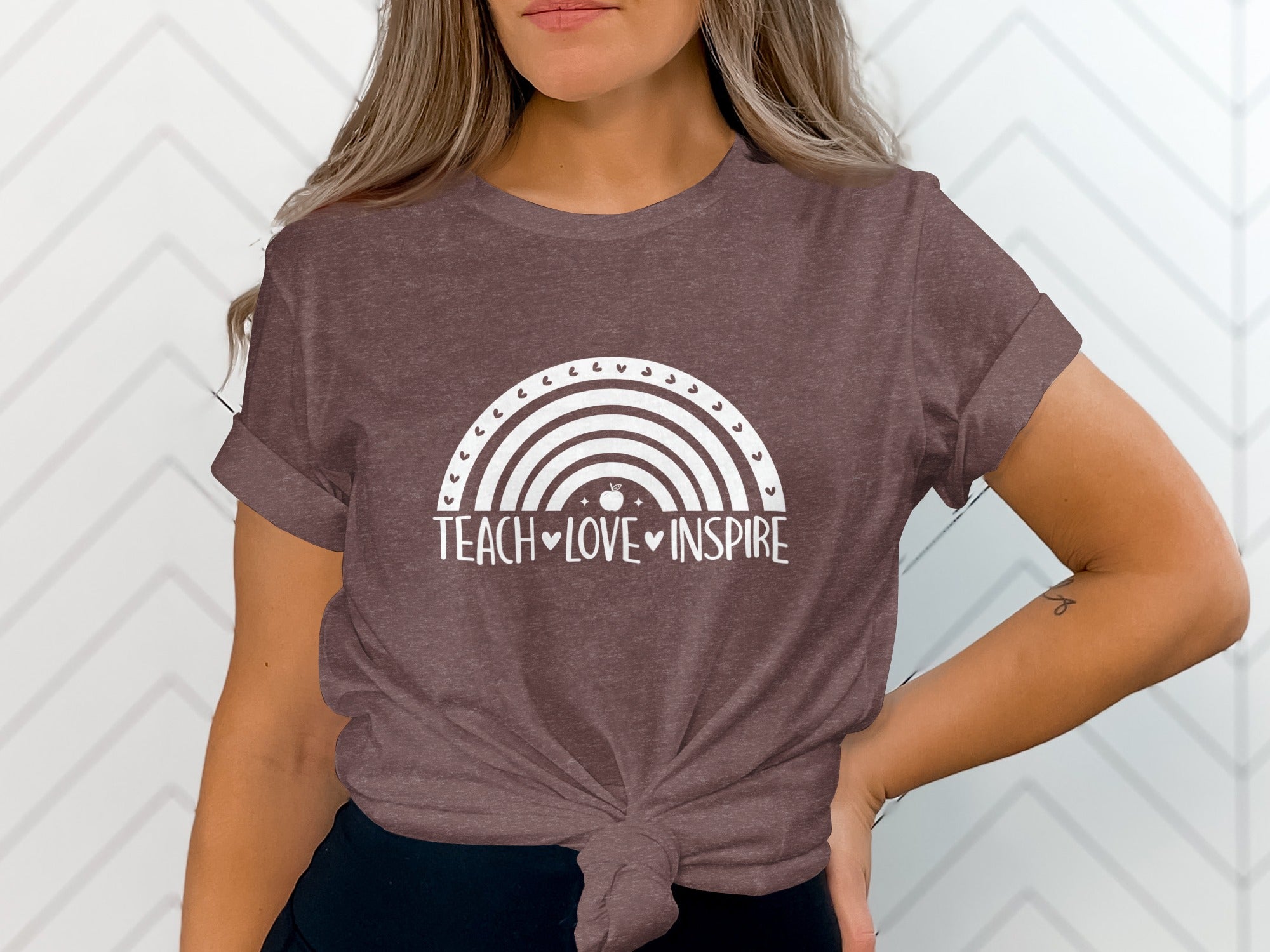 Brown t-shirt with white rainbow graphic and "Teach Love Inspire" text.