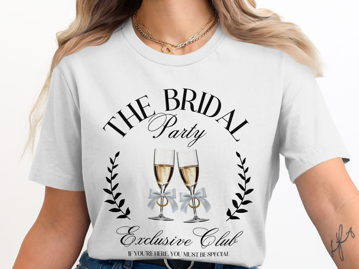 White t-shirt with "The Bridal Party Exclusive Club" text, champagne glasses, and rings.
