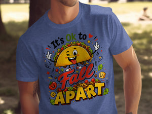Taco graphic with text "It's Ok to Fall Apart" on a blue t-shirt.