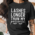 Black t-shirt with white text reading "Lashes longer than my patience" and eyelashes.