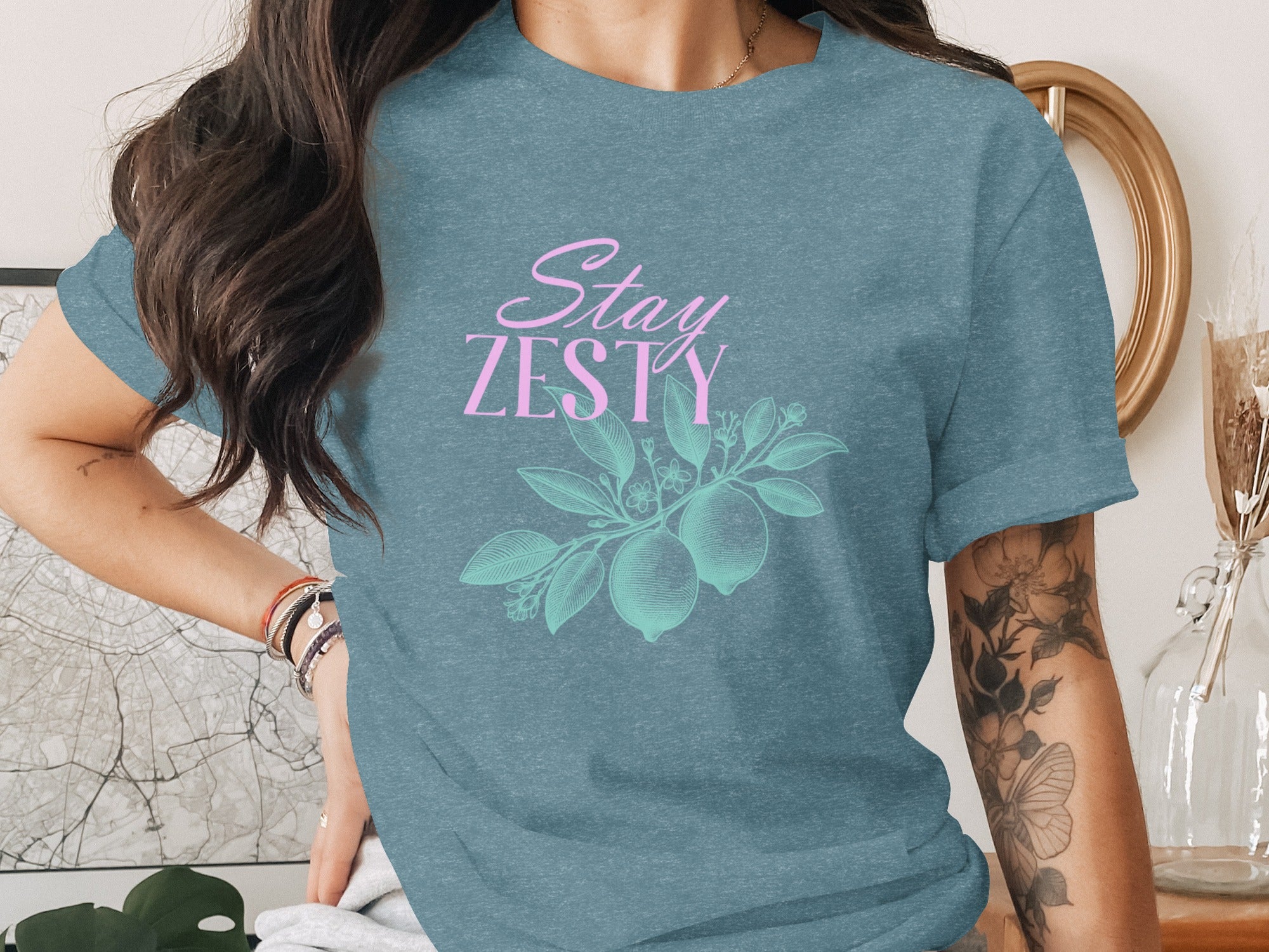 Dusty blue t-shirt with pink "Stay Zesty" text and a teal lemon branch design.