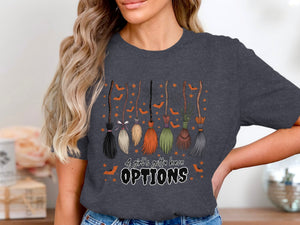 Dark grey t-shirt with a Halloween graphic of brooms, bats, and stars that says "A girl's gotta have OPTIONS".