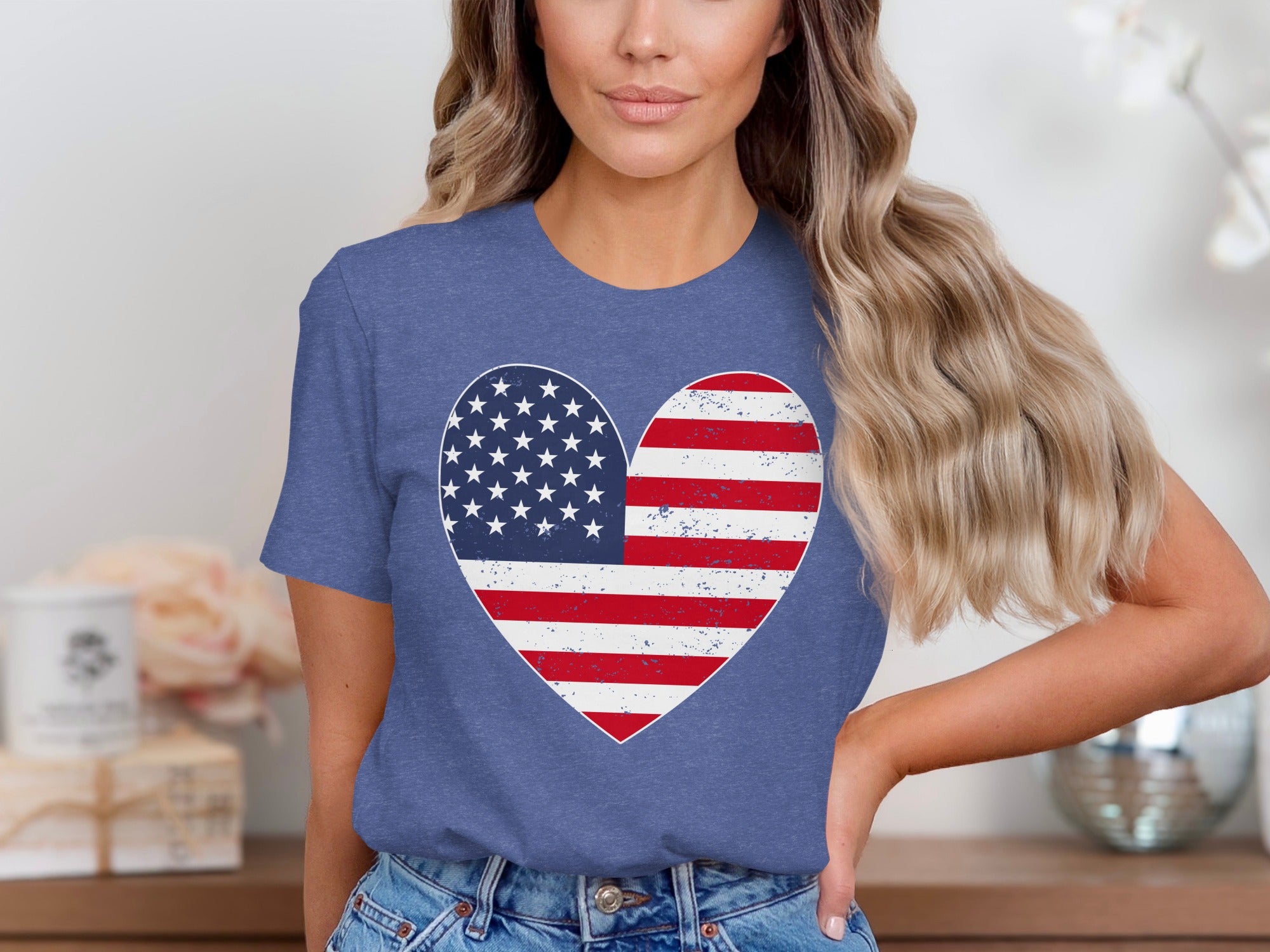 Woman wearing a blue t-shirt with a distressed American flag heart graphic.
