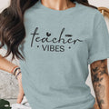 Light blue t-shirt with black text: "teacher VIBES" and subtle graphics.