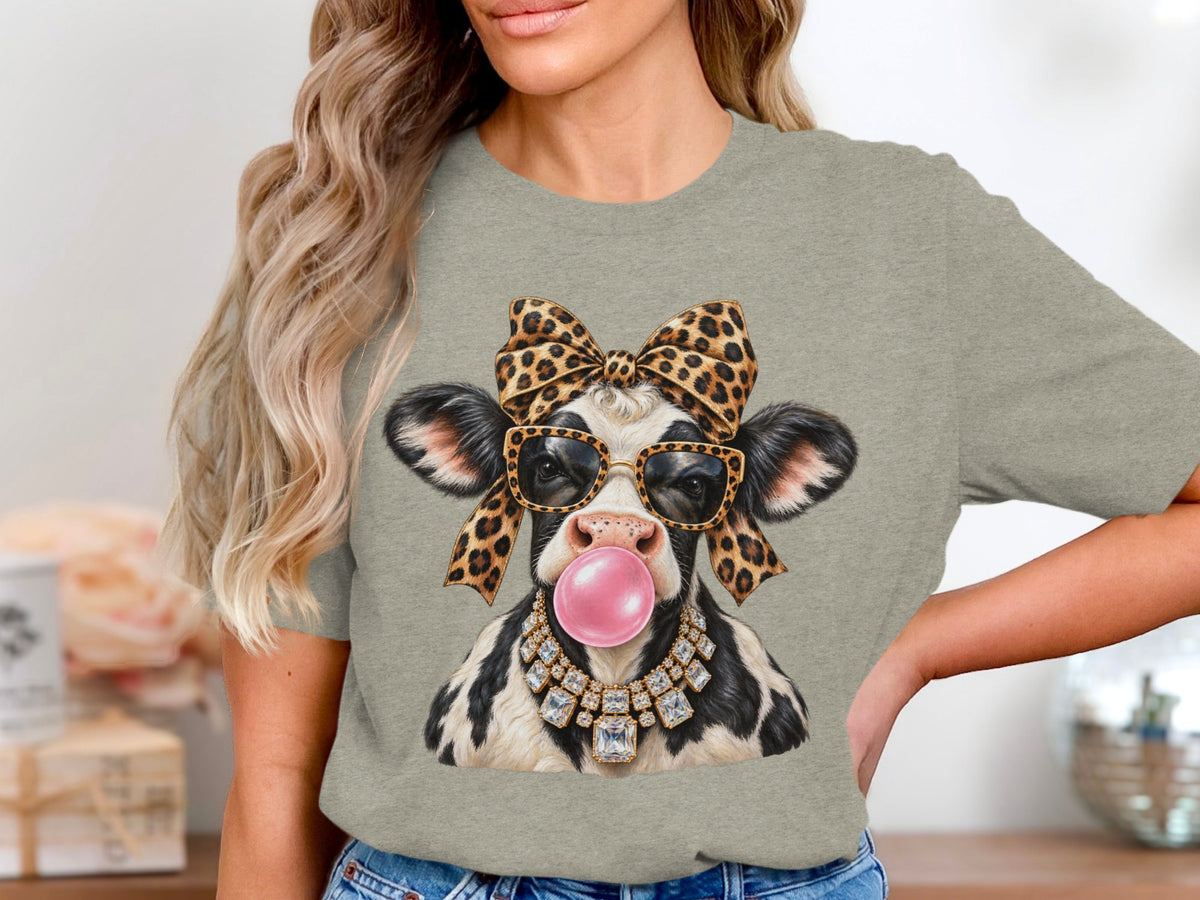 Cow with leopard bow, sunglasses, gum, and diamond necklace on t-shirt.