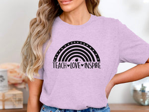 Light purple t-shirt with black rainbow graphic and "Teach Love Inspire" text.