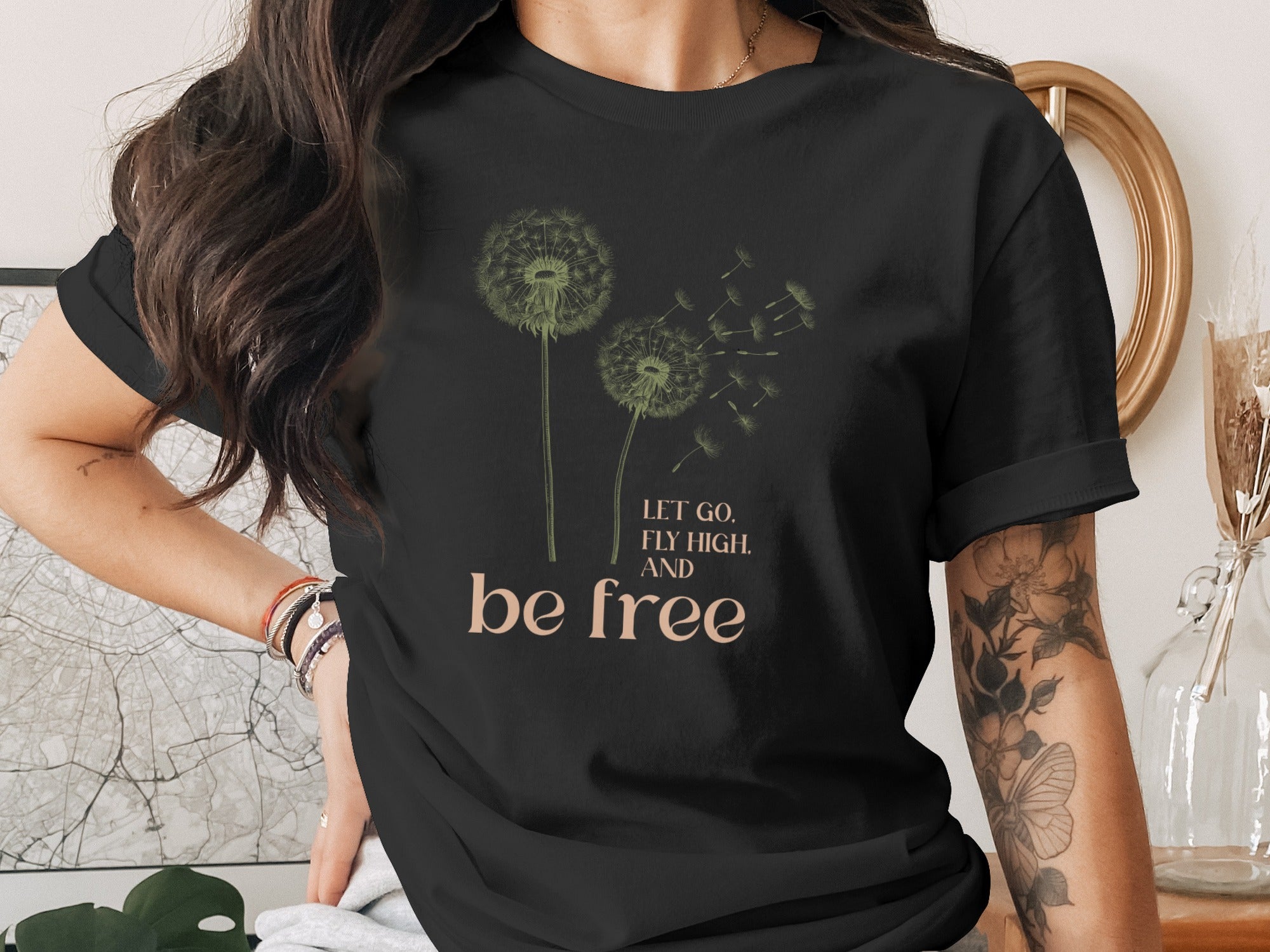 Black t-shirt with dandelions and text "Let go, fly high, and be free."