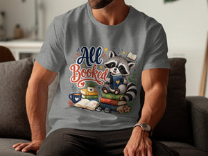 Raccoon sitting on books, text "All Booked", coffee cup and glasses.