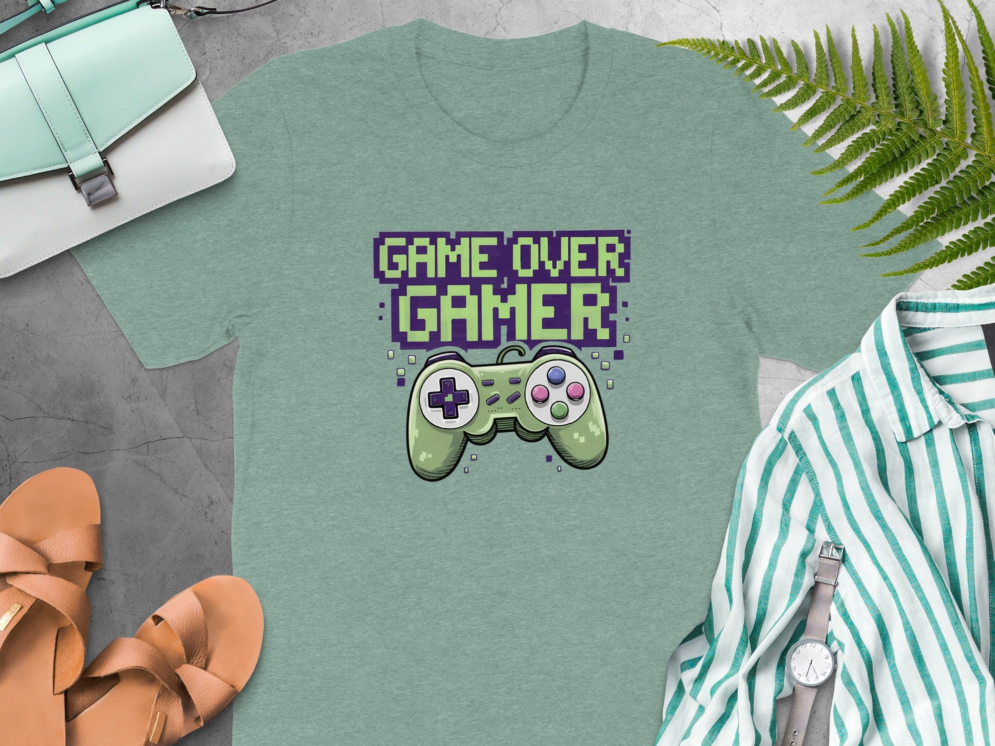 Green t-shirt with pixelated "GAME OVER GAMER" text and a retro video game controller.
