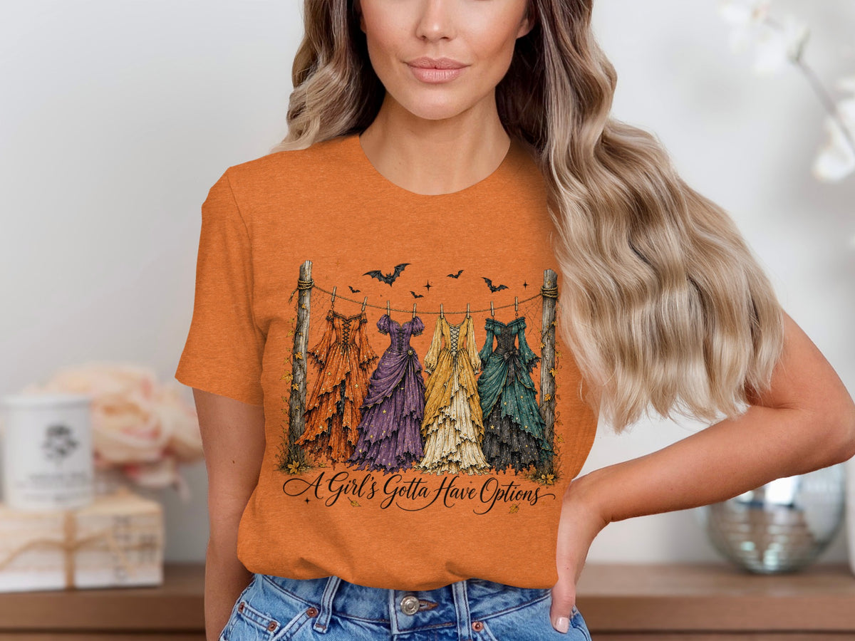 Orange t-shirt with a graphic of five dresses hanging on a line and text.