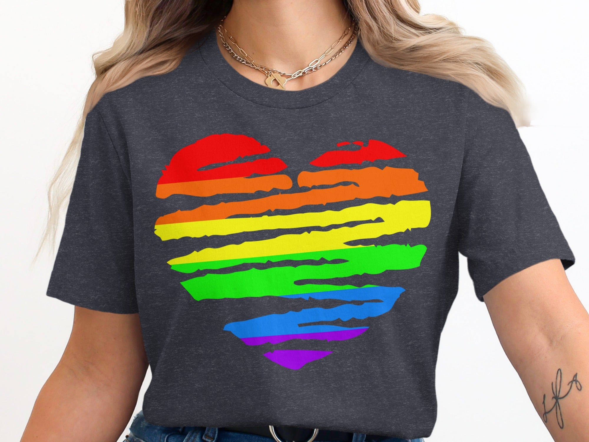 Dark gray t-shirt with a rainbow heart graphic and two gold necklaces.