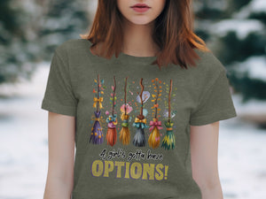 T-shirt graphic with decorative brooms and text "A girl's gotta have OPTIONS!".