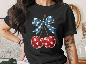 Black t-shirt with patriotic cherries and star-spangled bow graphic.