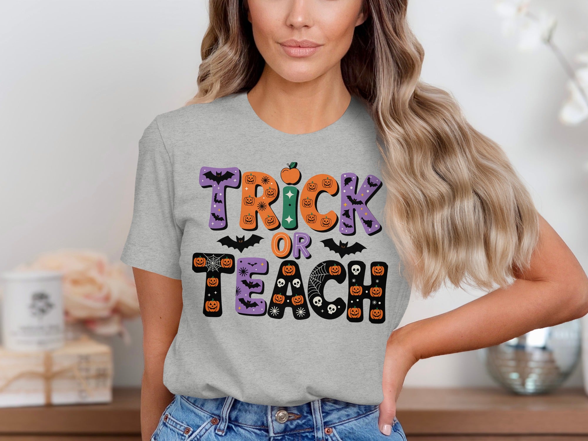 Grey t-shirt with "Trick Or Teach" Halloween graphic featuring pumpkins, bats, and skulls.