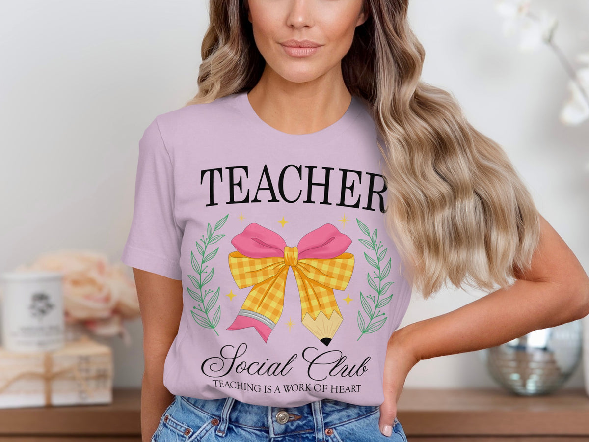 Light purple t-shirt with text "TEACHER Social Club" and a pencil bow graphic.