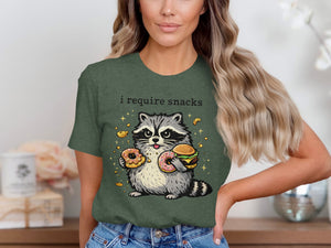 T-shirt graphic of a raccoon holding donuts and a burger, with "i require snacks" text above.
